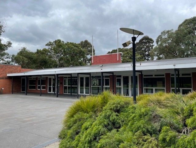 Surrey Park Swimming Club rooms. Red brick building with White floor to ceiling windows. Green shrubs out the front