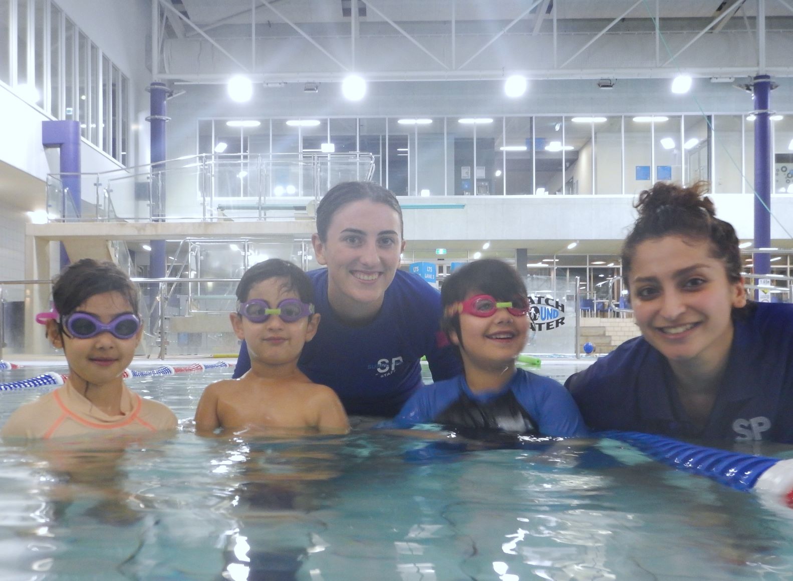 Three refugees learning how to swim with our teachers